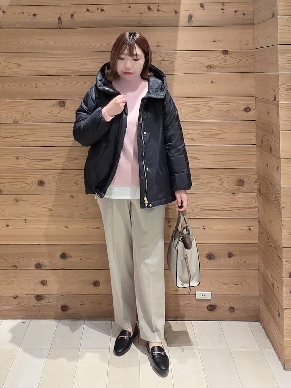 ブラック系のローファー、ホワイト系のショルダーバッグ、ブルー系のダウンジャケット/コートを着用したレディースの冬コーディネートの4枚目の写真