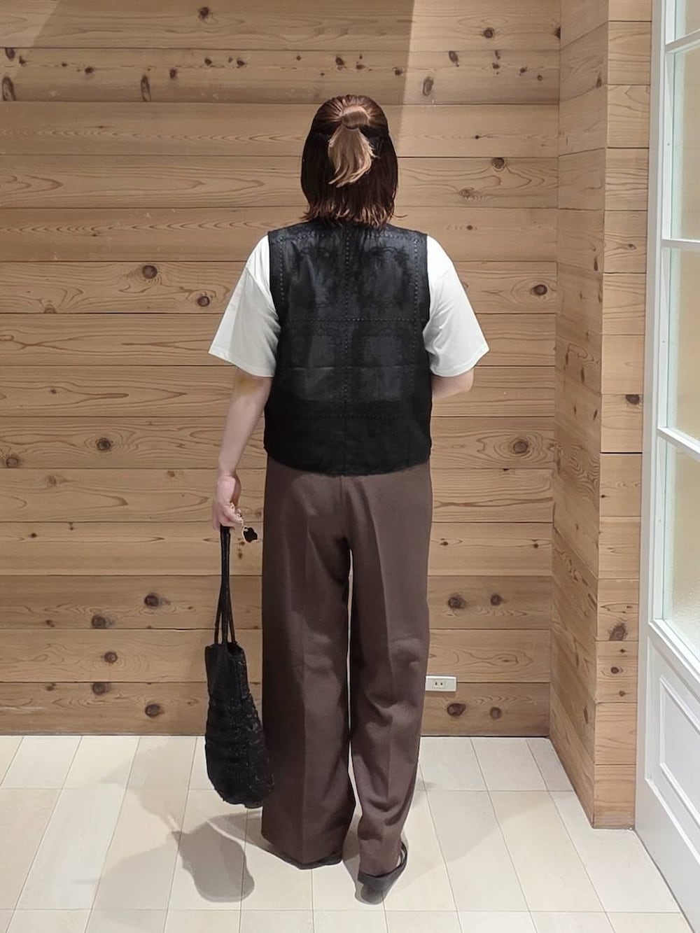 ブラウン系のその他パンツ、ホワイト系のTシャツ/カットソー、ブラック系のクラッチバッグを着用したレディースの夏コーディネートの3枚目の写真