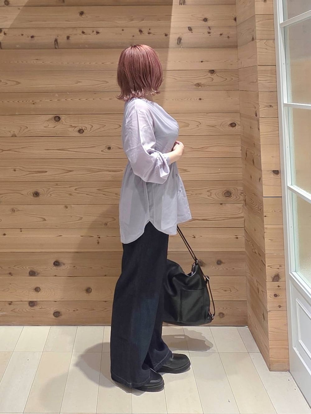 ブラック系のローファー、ブルー系のデニムパンツ、ブラック系のタンクトップを着用したレディースの秋コーディネートの2枚目の写真