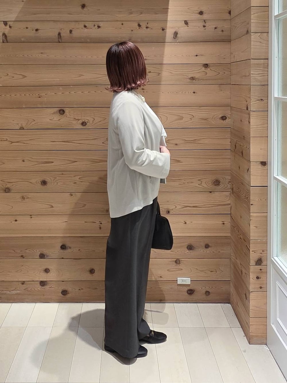 ブラック系のローファー、ブラック系のショルダーバッグ、ホワイト系のシャツ/ブラウスを着用したレディースの冬コーディネートの2枚目の写真