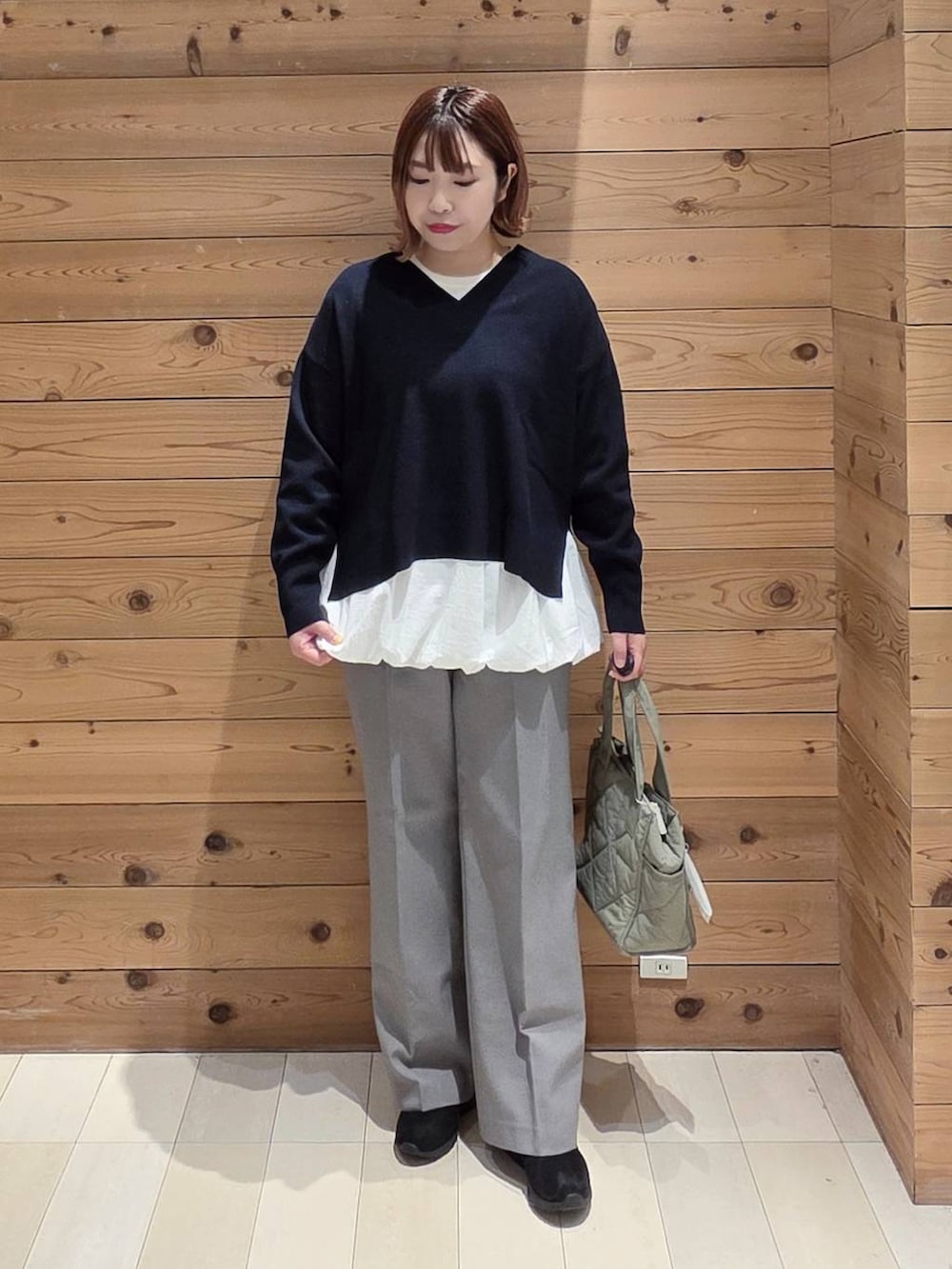 グリーン系のトートバッグ、ベージュ系のダウンジャケット/コート、ブラック系のブーツを着用したレディースの冬コーディネートの4枚目の写真