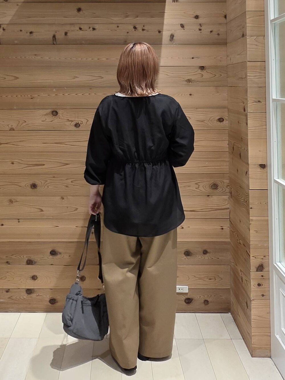 グレー系のショルダーバッグ、ブラック系のローファー、ホワイト系のTシャツ/カットソーを着用したレディースの秋コーディネートの3枚目の写真