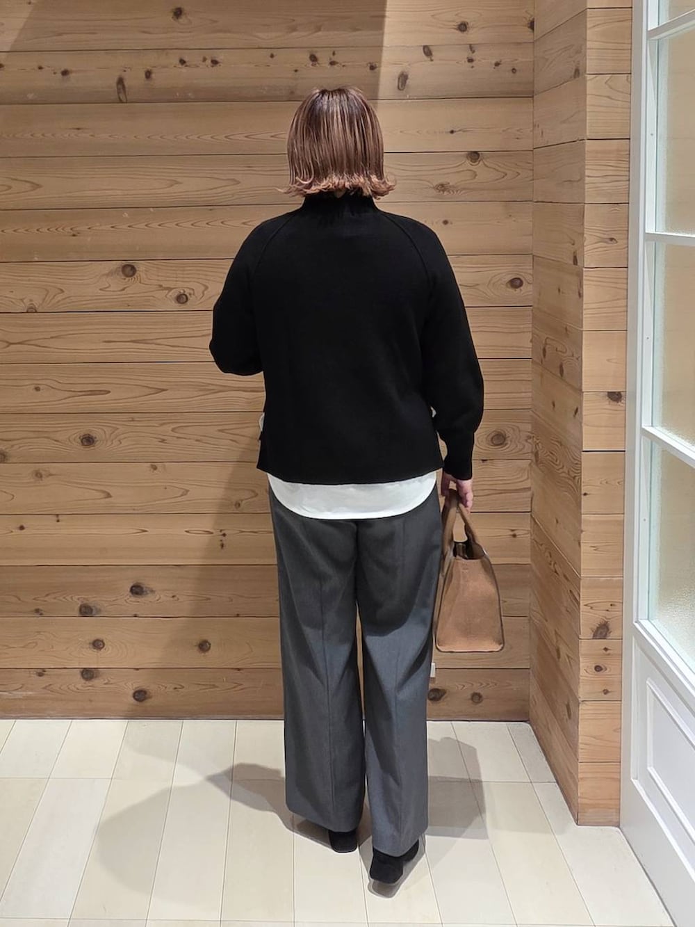 グレー系のチェスターコート、グレー系のその他パンツ、ベージュ系のショルダーバッグを着用したレディースの冬コーディネートの3枚目の写真