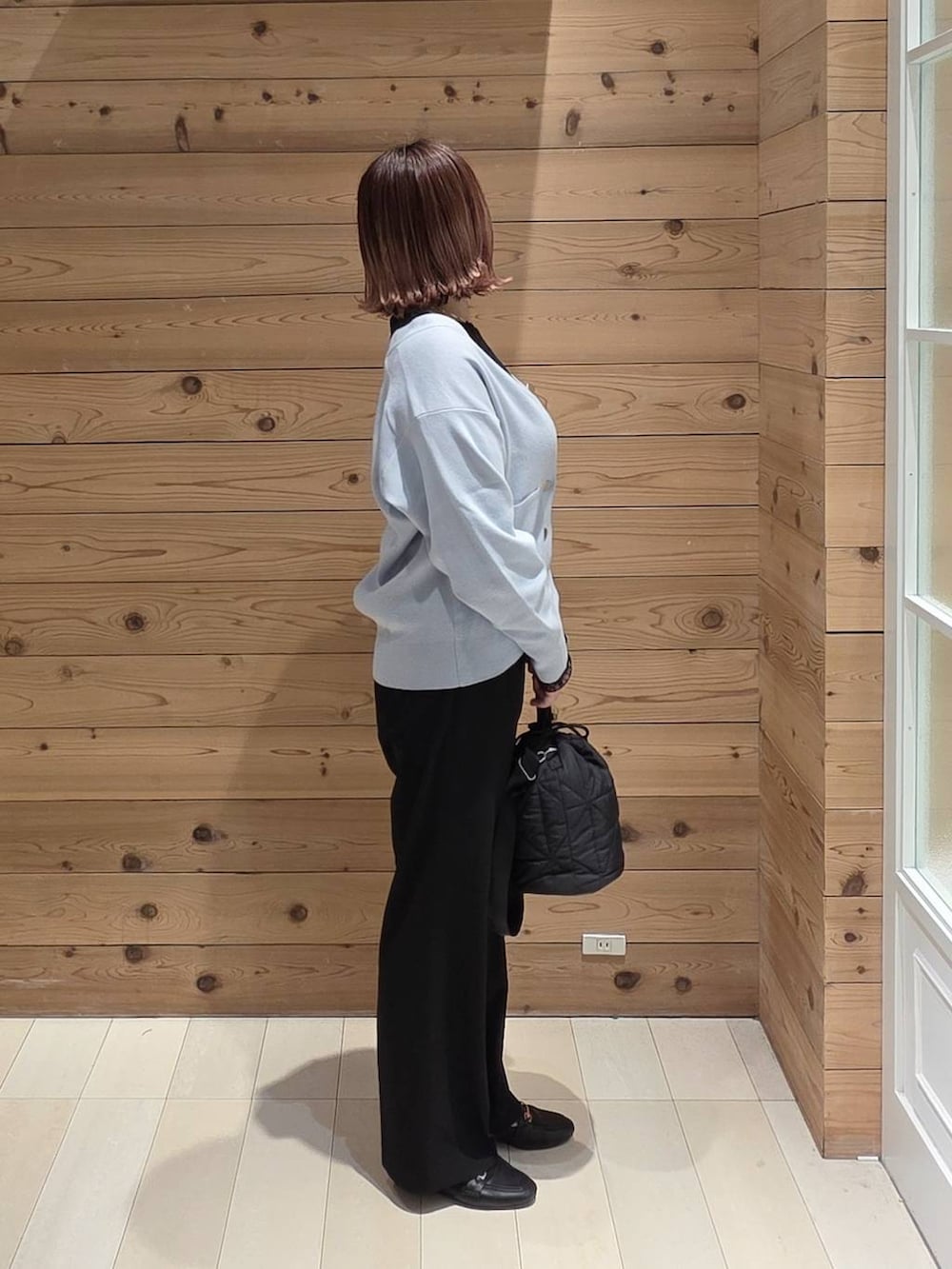 ブラック系のローファー、ブラック系のハンドバッグ、ブラック系のTシャツ/カットソーを着用したレディースの春コーディネートの2枚目の写真