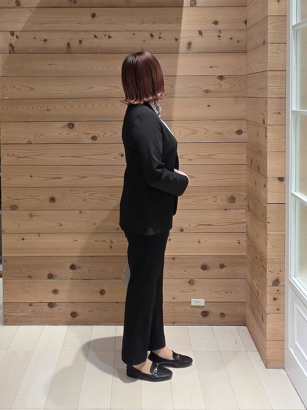 ブラック系のローファー、ホワイト系のショルダーバッグ、ブラック系のスラックスを着用したレディースの冬コーディネートの2枚目の写真