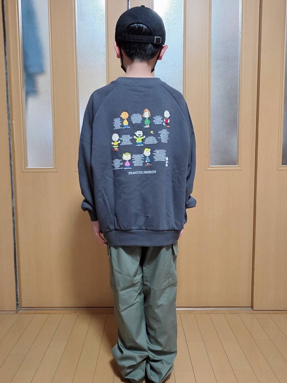 グリーン系のカーゴパンツ、ブラック系のブルゾン、グレー系のスウェットを着用したキッズの秋コーディネートの4枚目の写真