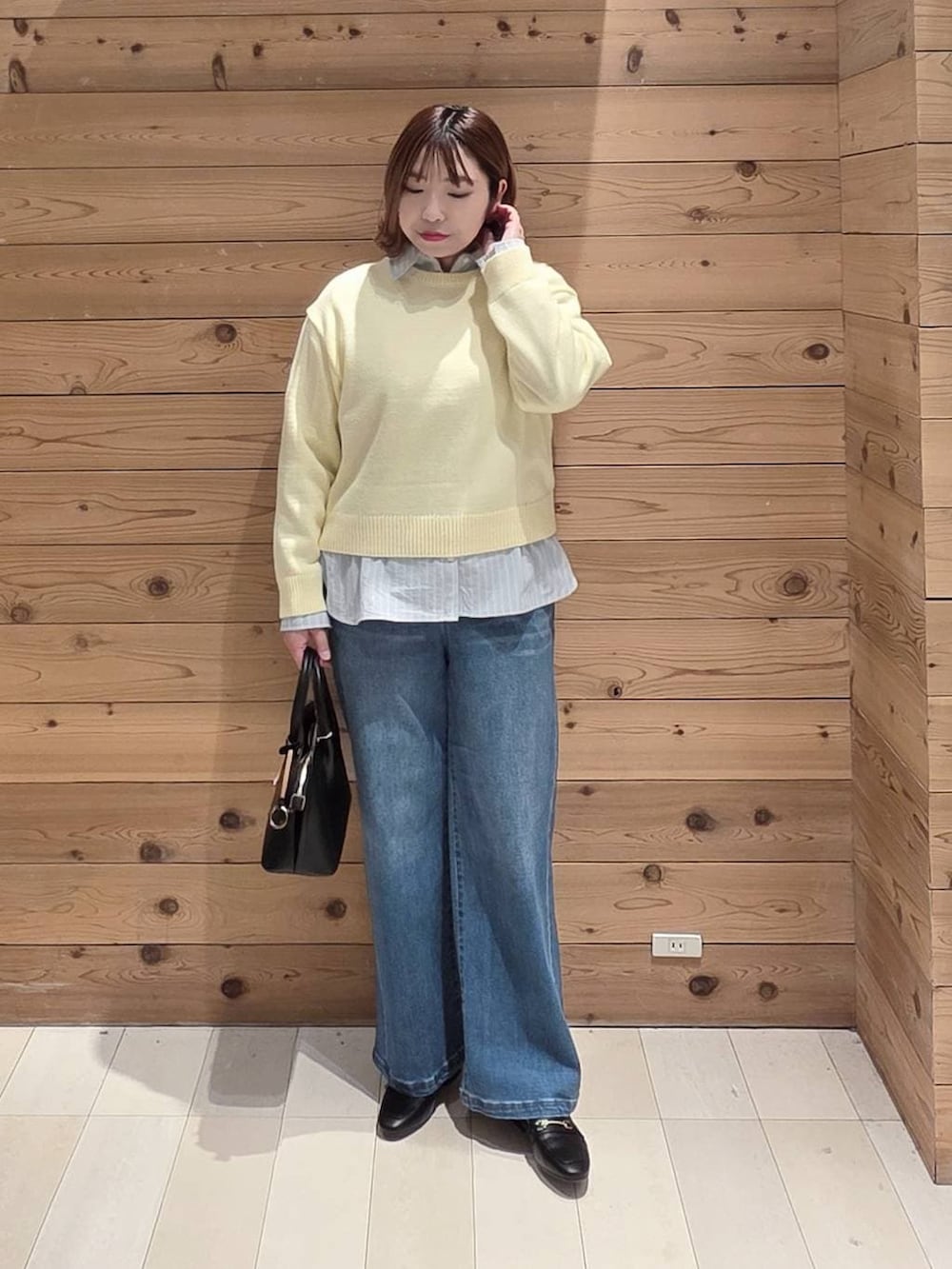 ブラック系のローファー、ブラック系のショルダーバッグ、ブルー系のダウンジャケット/コートを着用したレディースの冬コーディネートの4枚目の写真