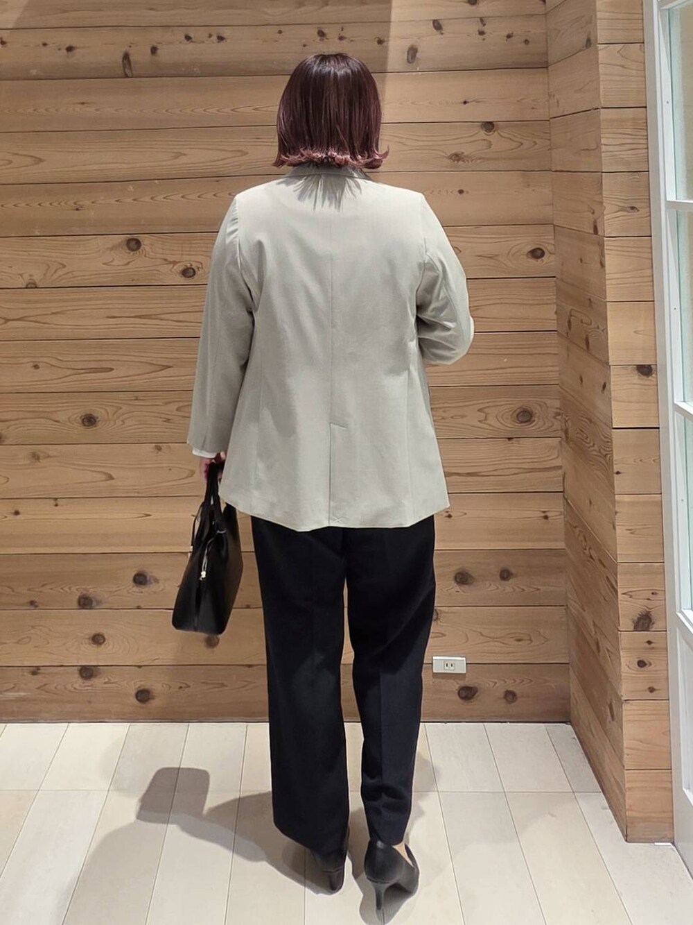 ブラック系のショルダーバッグ、ブラック系のパンプス、ベージュ系のテーラードジャケットを着用したレディースの冬コーディネートの3枚目の写真