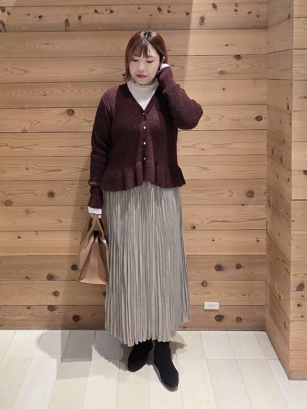 グレー系のチェスターコート、ベージュ系のショルダーバッグ、ホワイト系のTシャツ/カットソーを着用したレディースの冬コーディネートの4枚目の写真