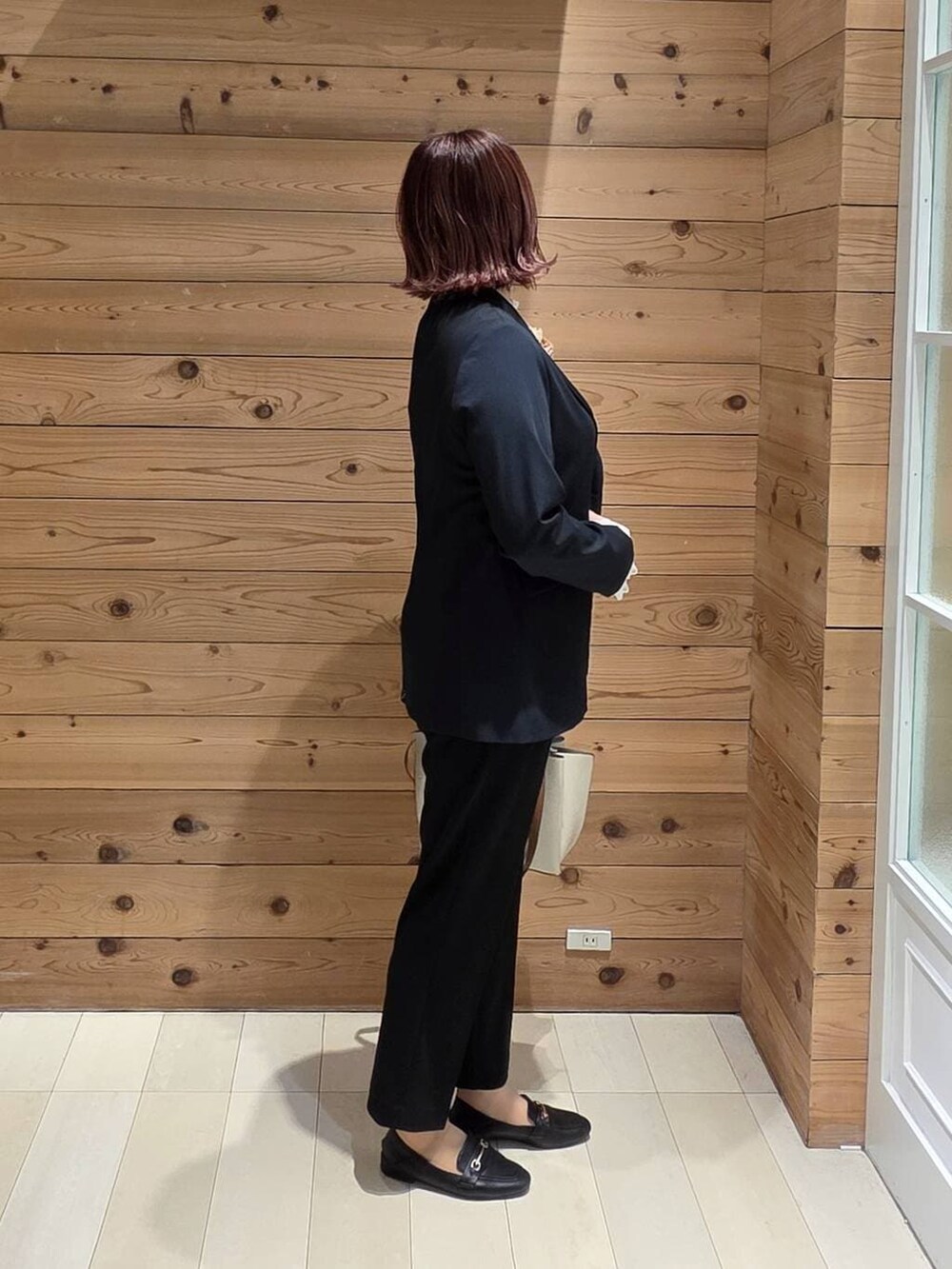 ブラック系のローファー、ホワイト系のシャツ/ブラウス、ブルー系のスラックスを着用したレディースの春コーディネートの2枚目の写真