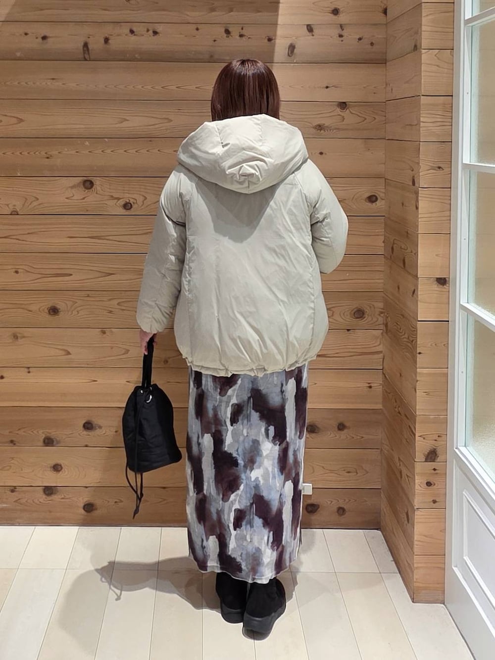 ベージュ系のダウンジャケット/コート、ブラック系のハンドバッグ、ブラック系のブーツを着用したレディースの冬コーディネートの3枚目の写真