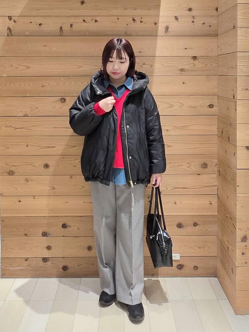 ブラック系のダウンジャケット/コート、ブラック系のボストンバッグ、ブルー系のシャツ/ブラウスを着用したレディースの冬コーディネートの4枚目の写真