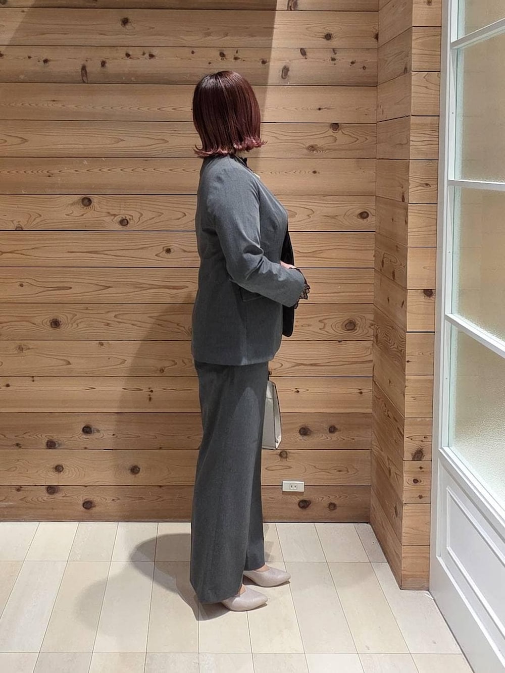 ホワイト系のショルダーバッグ、ホワイト系のパンプス、ブラック系のシャツ/ブラウスを着用したレディースの冬コーディネートの2枚目の写真