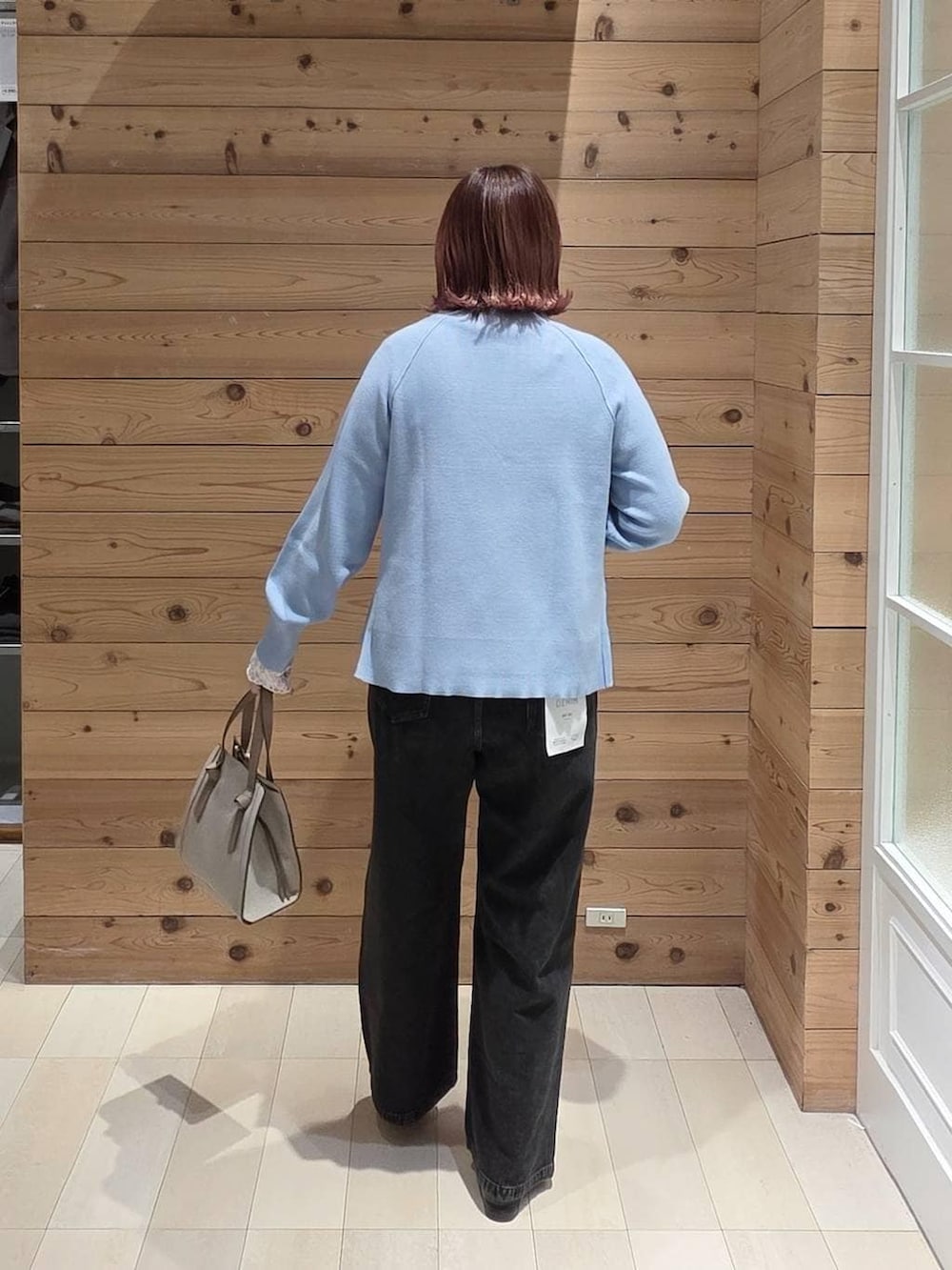 ブラック系のローファー、ホワイト系のショルダーバッグ、ブラック系のデニムパンツを着用したレディースの冬コーディネートの3枚目の写真