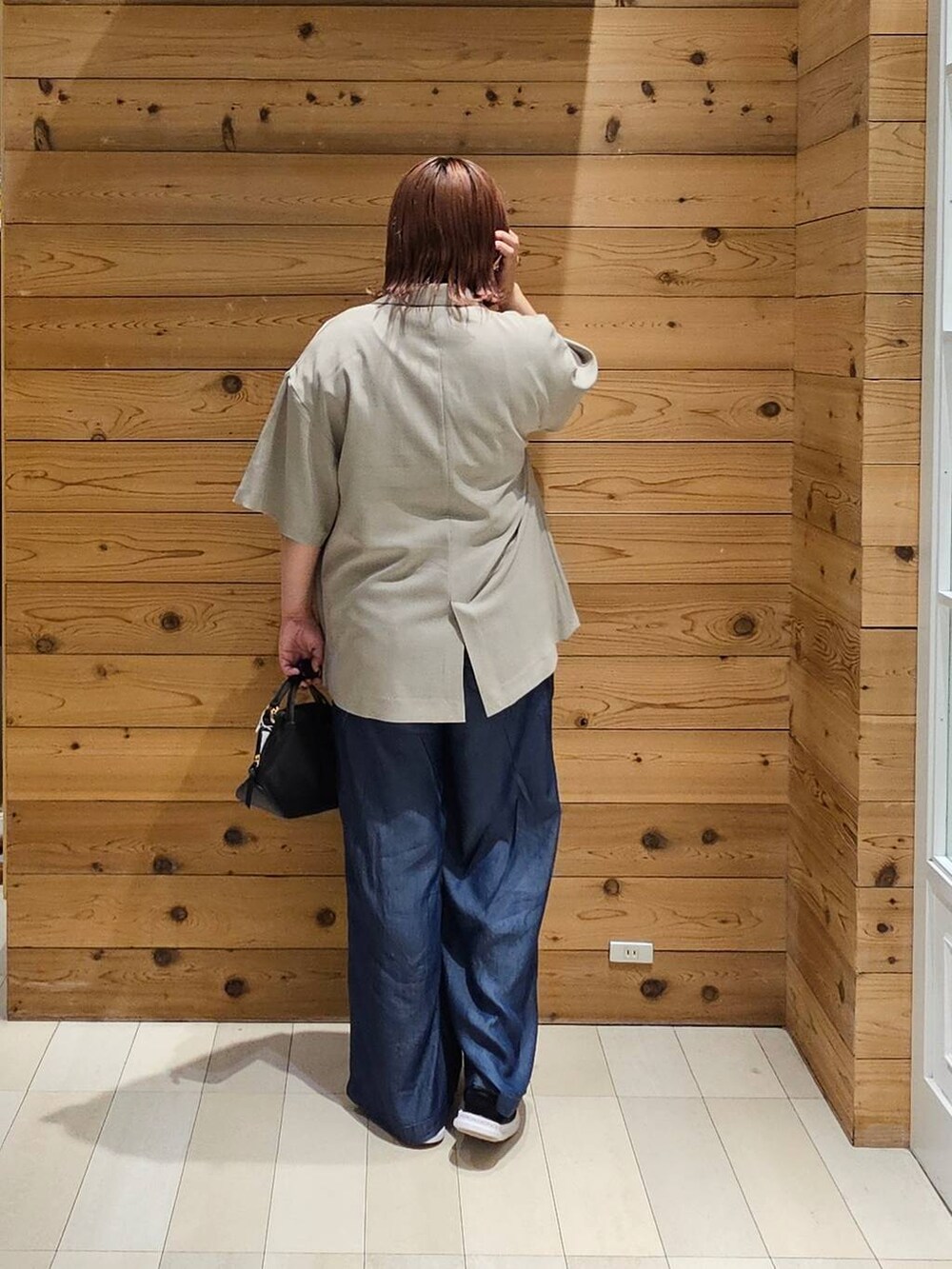 ブラック系のショルダーバッグ、ホワイト系のTシャツ/カットソー、ベージュ系のテーラードジャケットを着用したレディースの夏コーディネートの3枚目の写真