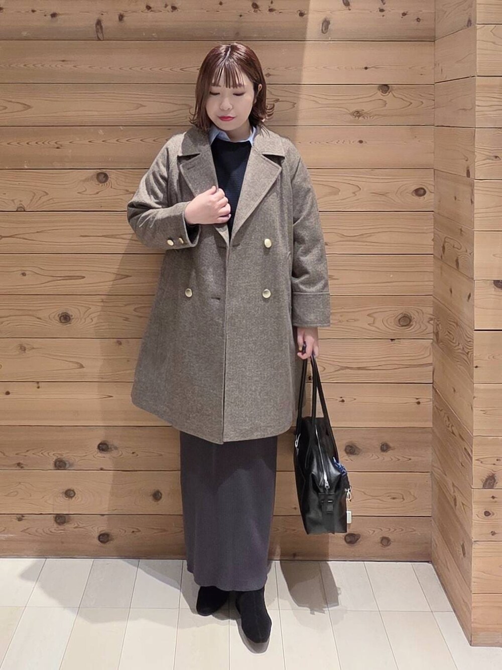 ブラック系のボストンバッグ、ブラウン系のチェスターコート、ブルー系のシャツ/ブラウスを着用したレディースの冬コーディネートの4枚目の写真