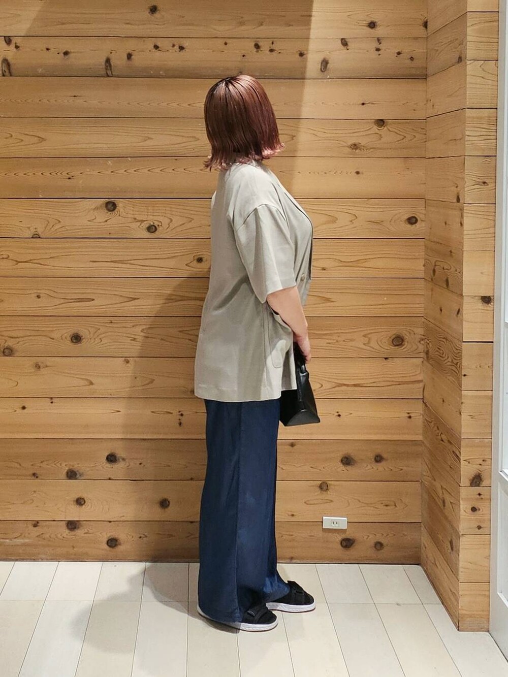 ブラック系のショルダーバッグ、ホワイト系のTシャツ/カットソー、ベージュ系のテーラードジャケットを着用したレディースの夏コーディネートの2枚目の写真