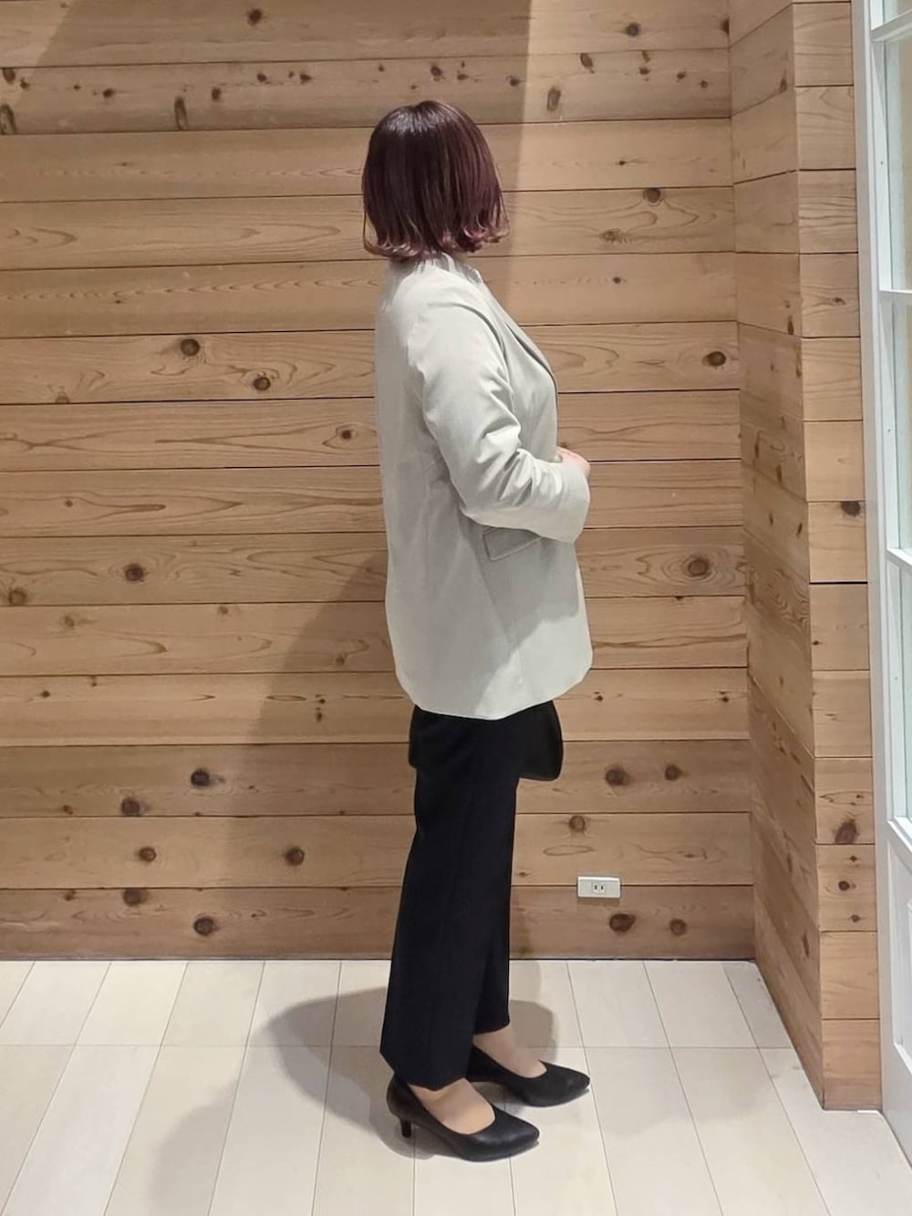 ブラック系のショルダーバッグ、ブラック系のパンプス、ブルー系のセットアップを着用したレディースの冬コーディネートの2枚目の写真