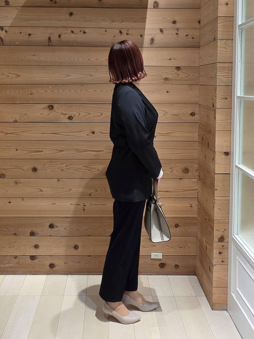 ホワイト系のショルダーバッグ、ホワイト系のパンプス、ホワイト系のTシャツ/カットソーを着用したレディースの冬コーディネートの2枚目の写真