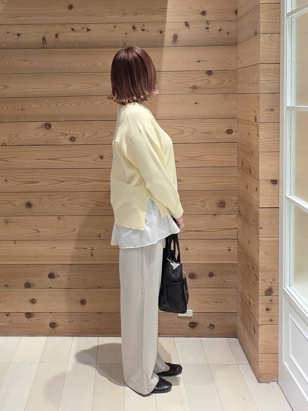 ブラック系のバレエシューズ、ブラック系のトートバッグ、グレー系のパーカーを着用したレディースの春コーディネートの2枚目の写真