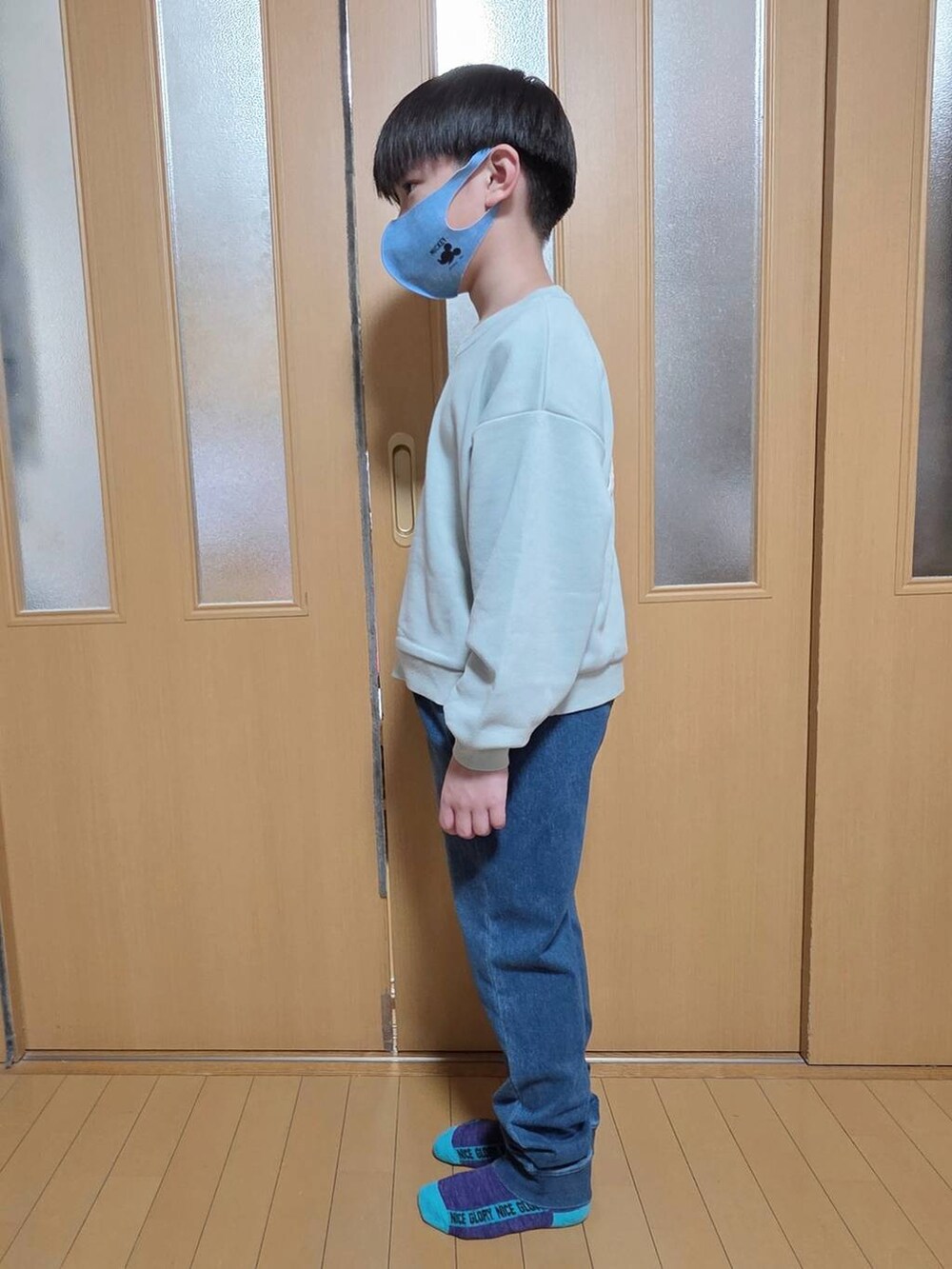 ブルー系のデニムパンツ、ブラック系のブルゾン、グリーン系のスウェットを着用したキッズの秋コーディネートの3枚目の写真