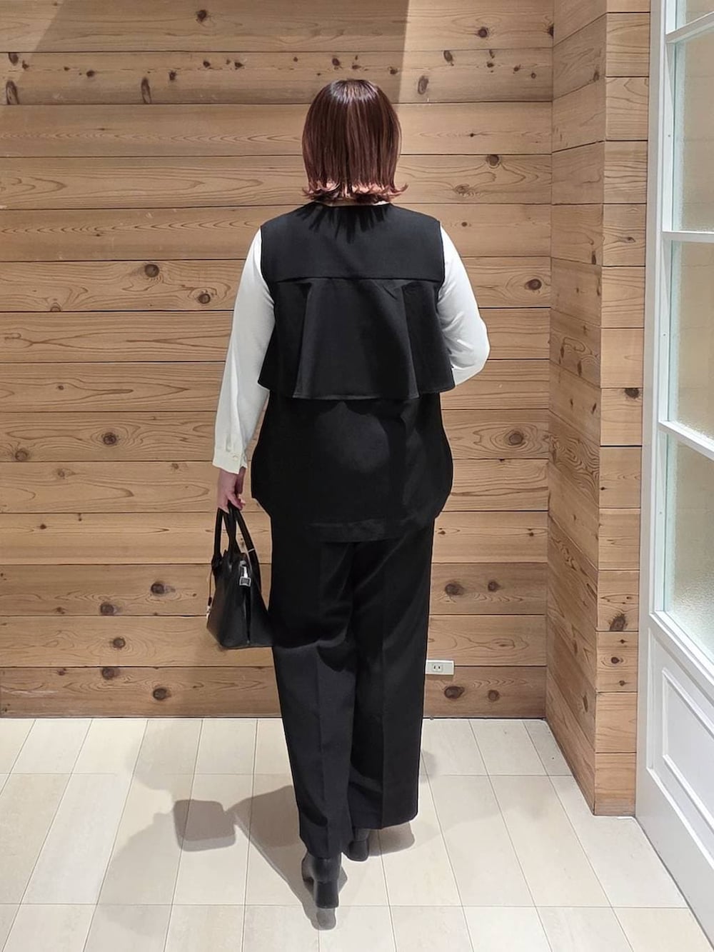 ブラック系のローファー、ブラック系のショルダーバッグ、ホワイト系のシャツ/ブラウスを着用したレディースの冬コーディネートの3枚目の写真