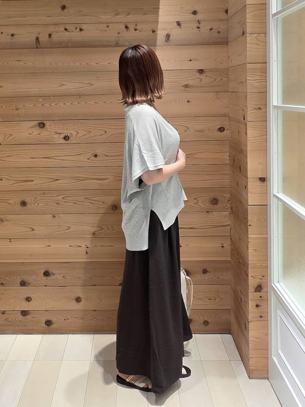 グレー系のカーディガン/ボレロ、ホワイト系のタンクトップ、ブラウン系のその他パンツを着用したレディースの夏コーディネートの2枚目の写真