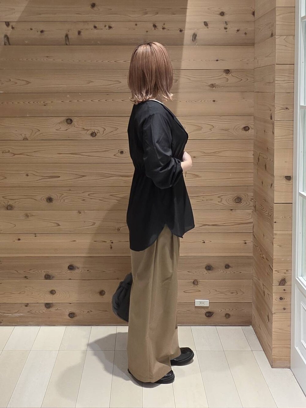 グレー系のショルダーバッグ、ブラック系のローファー、ホワイト系のTシャツ/カットソーを着用したレディースの秋コーディネートの2枚目の写真