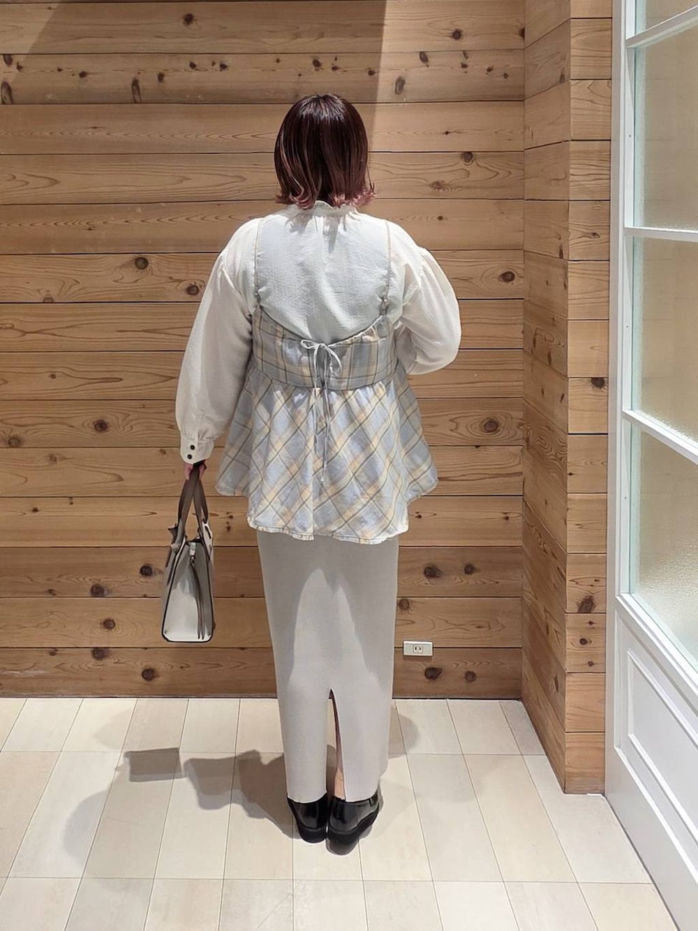 ブラック系のローファー、ホワイト系のショルダーバッグ、ブルー系のその他トップスを着用したレディースの冬コーディネートの3枚目の写真