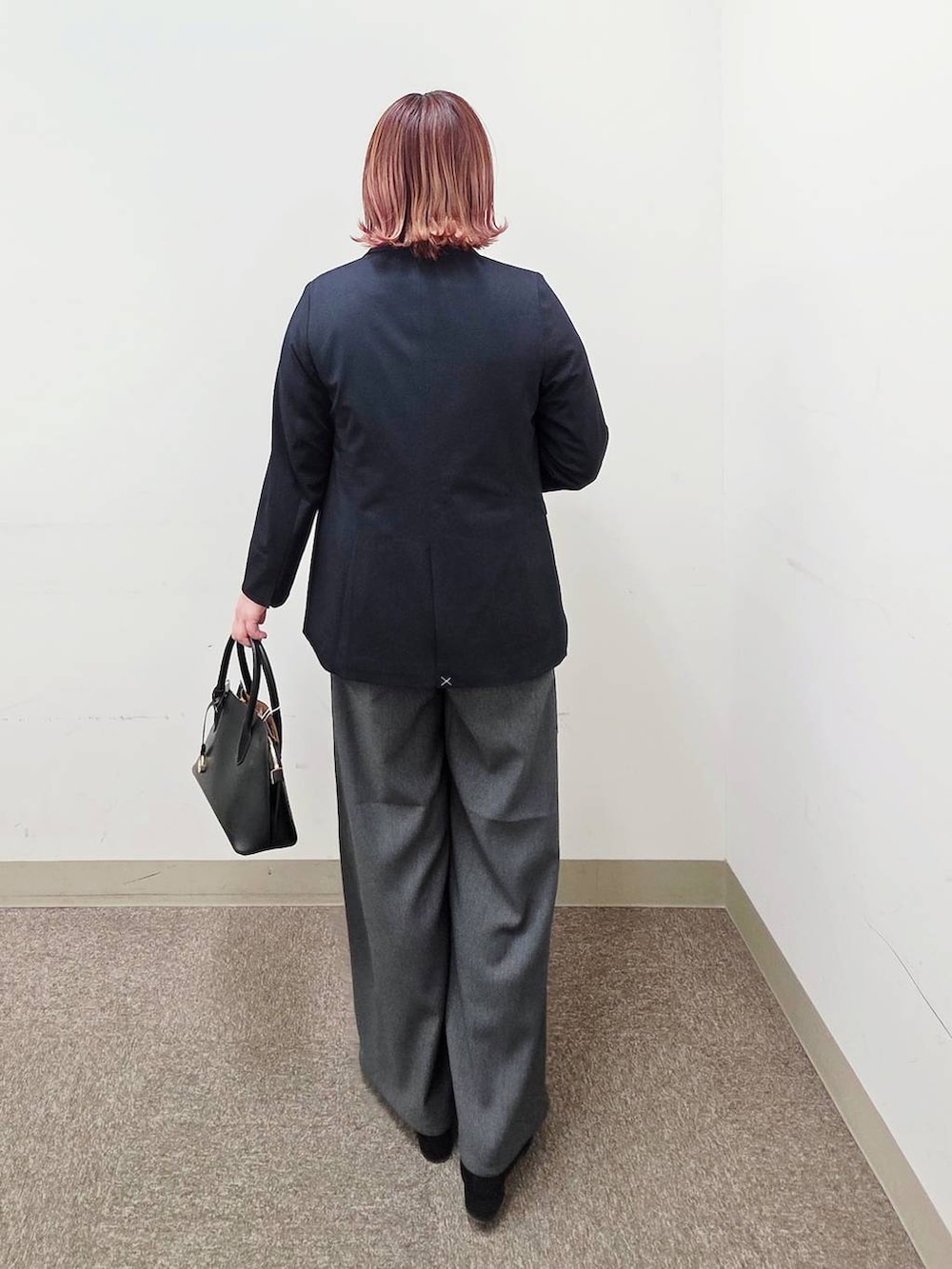 ブラック系のショルダーバッグ、ブラック系のパンプス、ブラック系のセットアップを着用したレディースの冬コーディネートの3枚目の写真