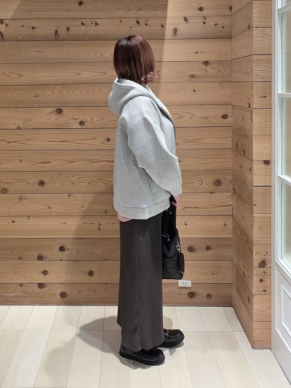 ブラック系のローファー、ブラック系のトートバッグ、ピンク系のニット/セーターを着用したレディースの冬コーディネートの2枚目の写真