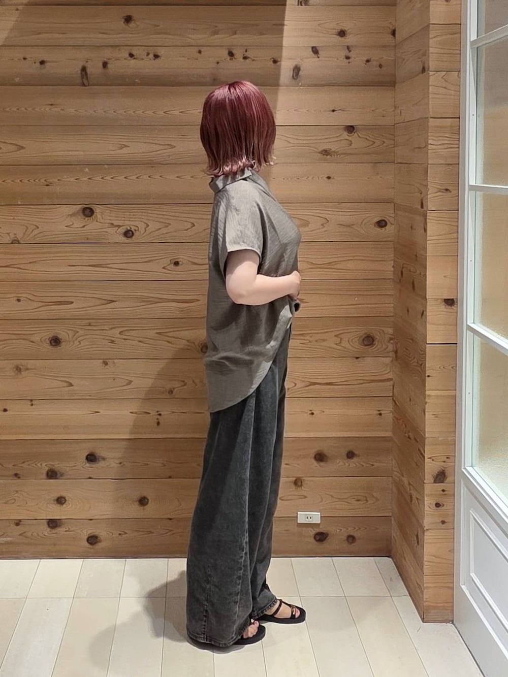 ブラック系のデニムパンツ、ブラック系のタンクトップ、ベージュ系のボディバッグ/ウエストポーチを着用したレディースの夏コーディネートの2枚目の写真