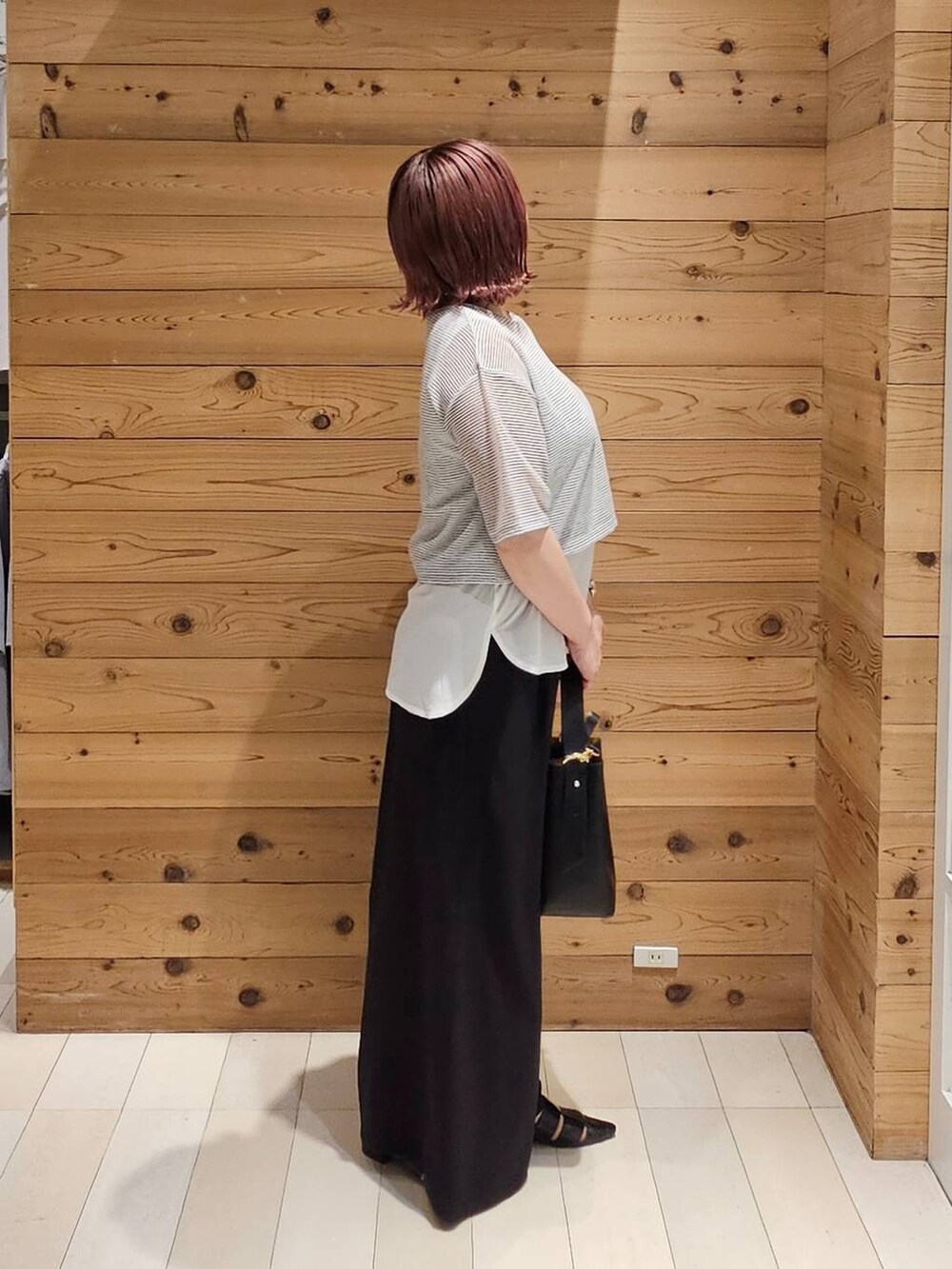 ブラック系のショルダーバッグ、ホワイト系のTシャツ/カットソー、ブラック系のパンプスを着用したレディースの夏コーディネートの2枚目の写真