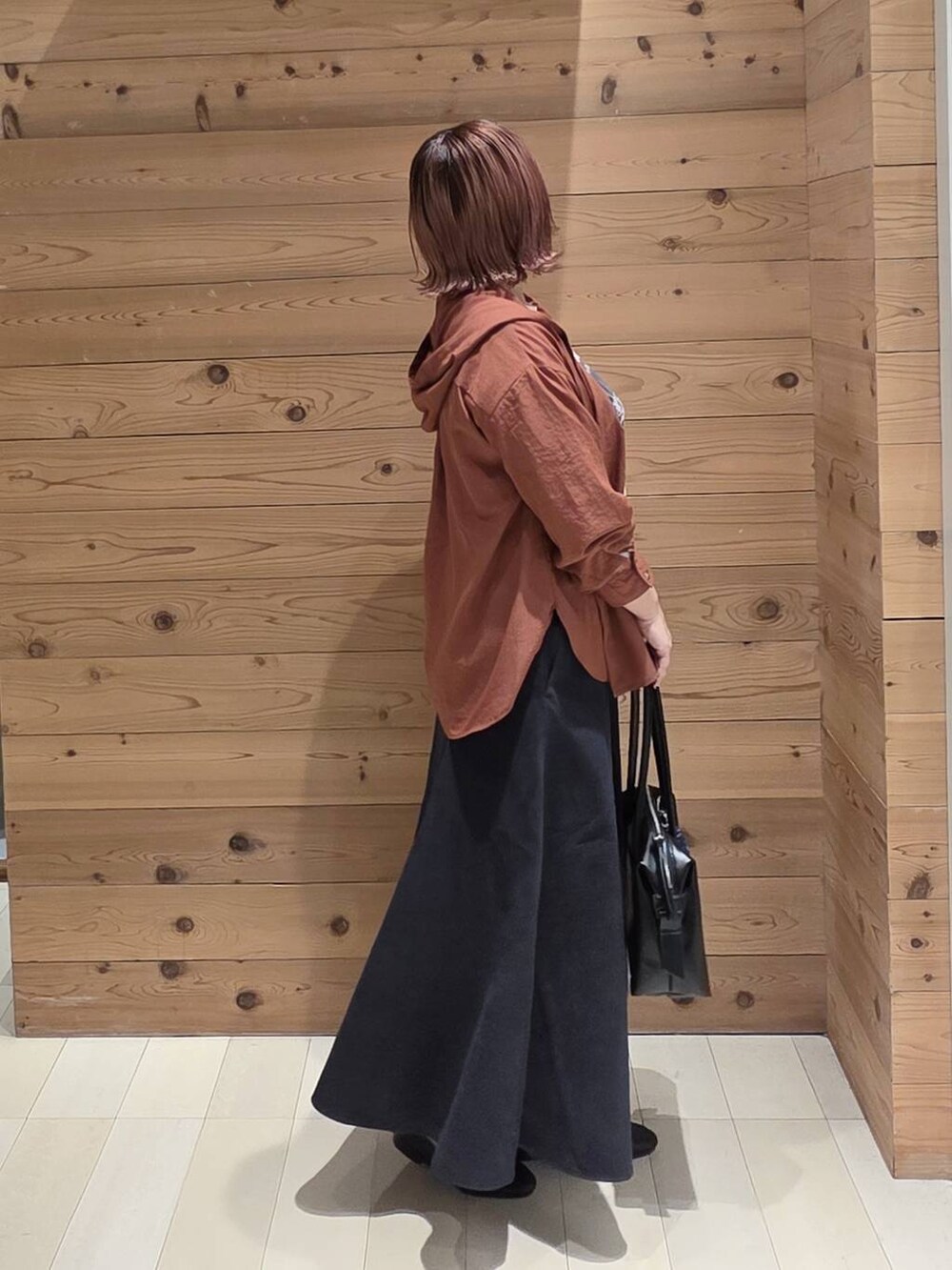 ブラック系のローファー、ブラック系のボストンバッグ、ブラウン系のシャツ/ブラウスを着用したレディースの秋コーディネートの2枚目の写真