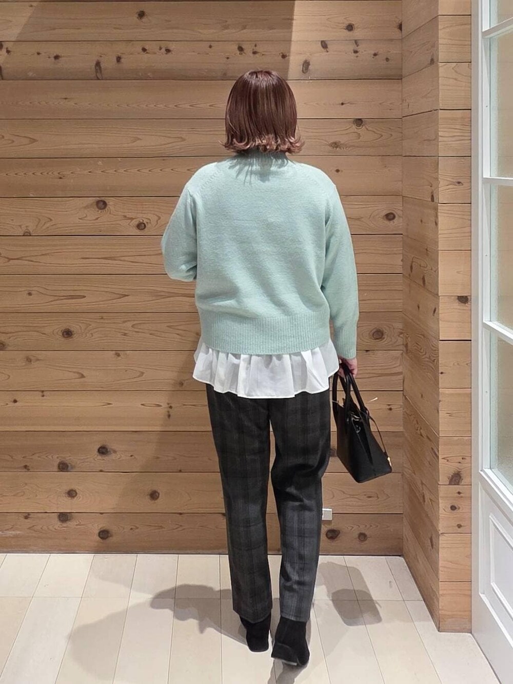 ブラック系のショルダーバッグ、ブラック系のダウンジャケット/コート、ブラック系のその他パンツを着用したレディースの冬コーディネートの3枚目の写真