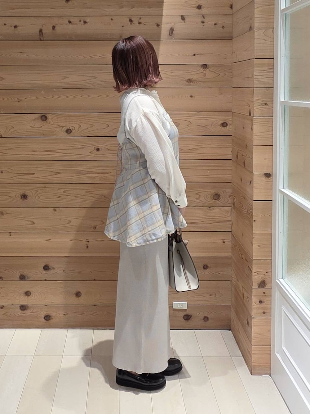 ブラック系のローファー、ホワイト系のショルダーバッグ、ブルー系のその他トップスを着用したレディースの冬コーディネートの2枚目の写真