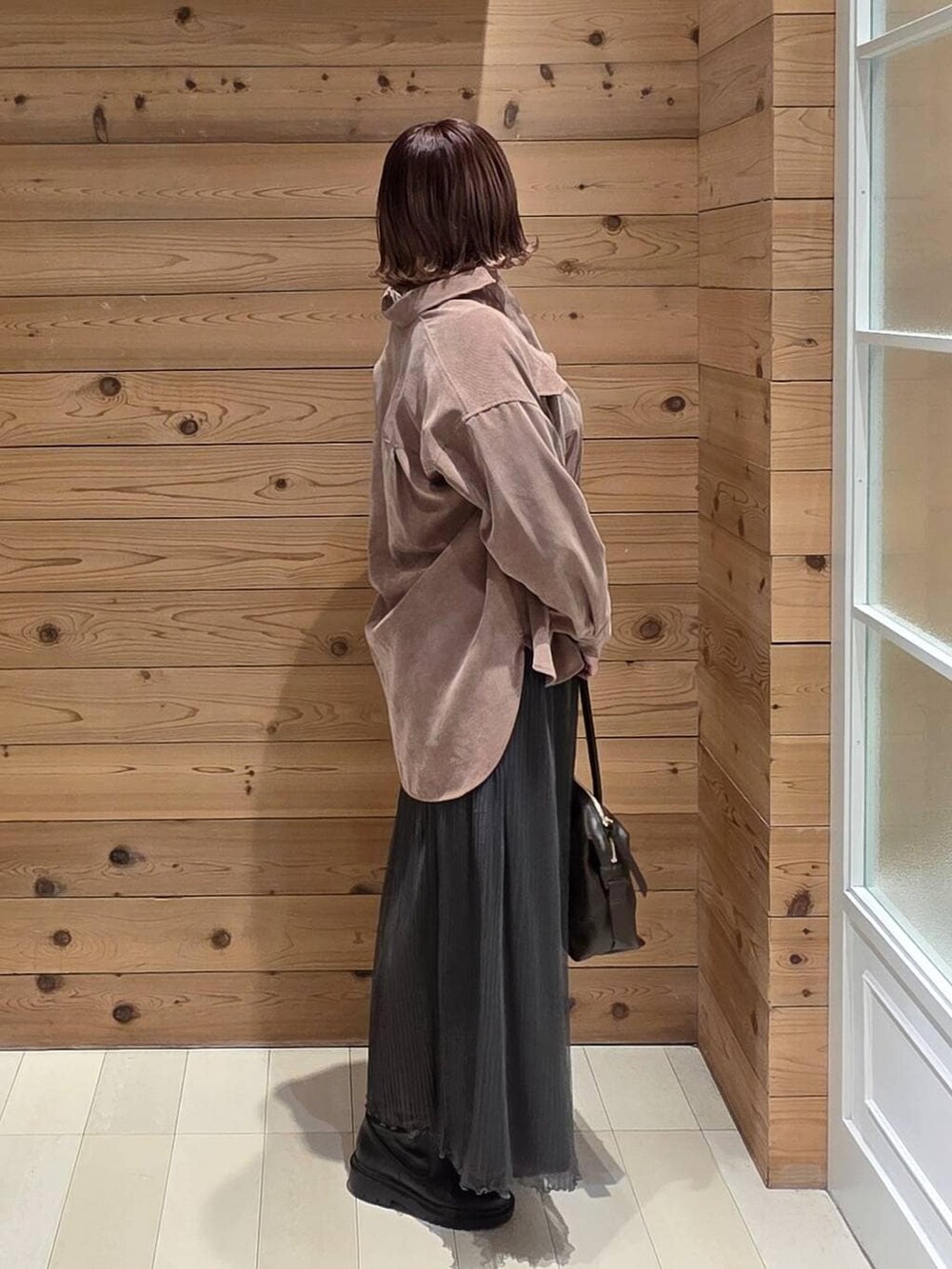 ブラウン系のボストンバッグ、ピンク系のシャツ/ブラウス、グレー系のニット/セーターを着用したレディースの秋コーディネートの2枚目の写真