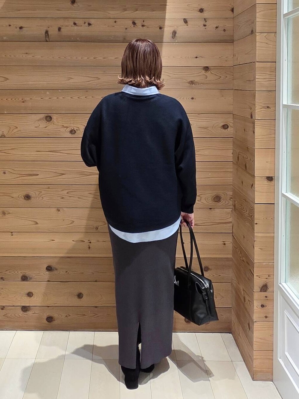 ブラック系のボストンバッグ、ブラウン系のチェスターコート、ブルー系のシャツ/ブラウスを着用したレディースの冬コーディネートの3枚目の写真