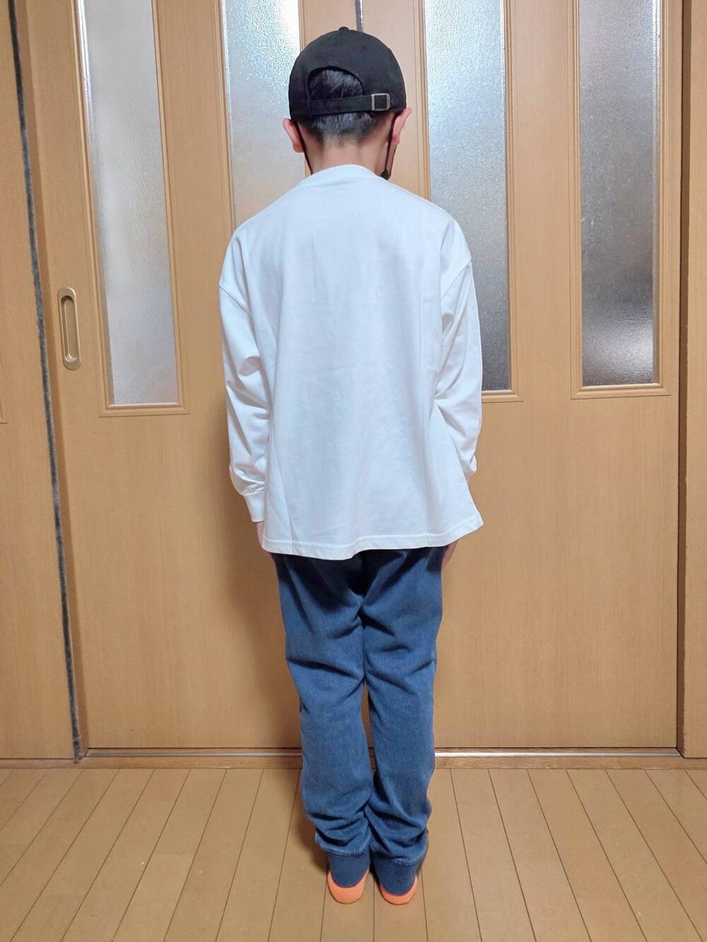 ブルー系のデニムパンツ、ホワイト系のTシャツ/カットソー、ブラック系のキャップを着用したキッズの秋コーディネートの3枚目の写真