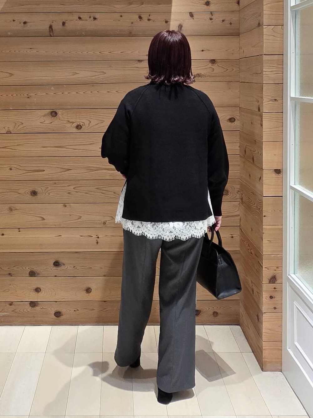 グレー系のチェスターコート、グレー系のその他パンツ、ブラック系のショルダーバッグを着用したレディースの冬コーディネートの3枚目の写真