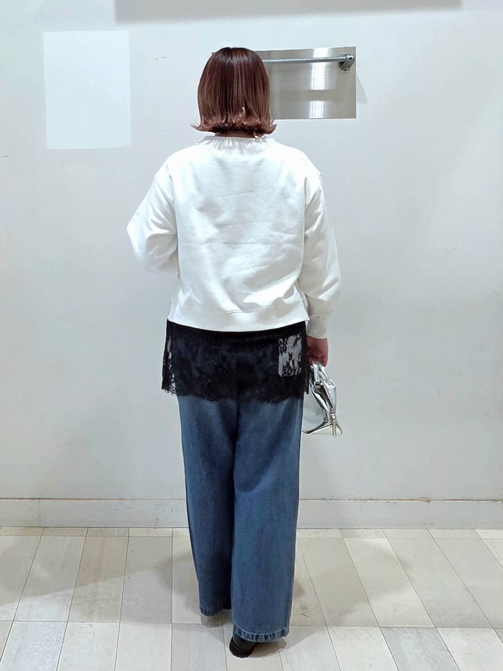 シルバー系のショルダーバッグ、ブラック系のローファー、ブルー系のデニムパンツを着用したレディースの春コーディネートの3枚目の写真