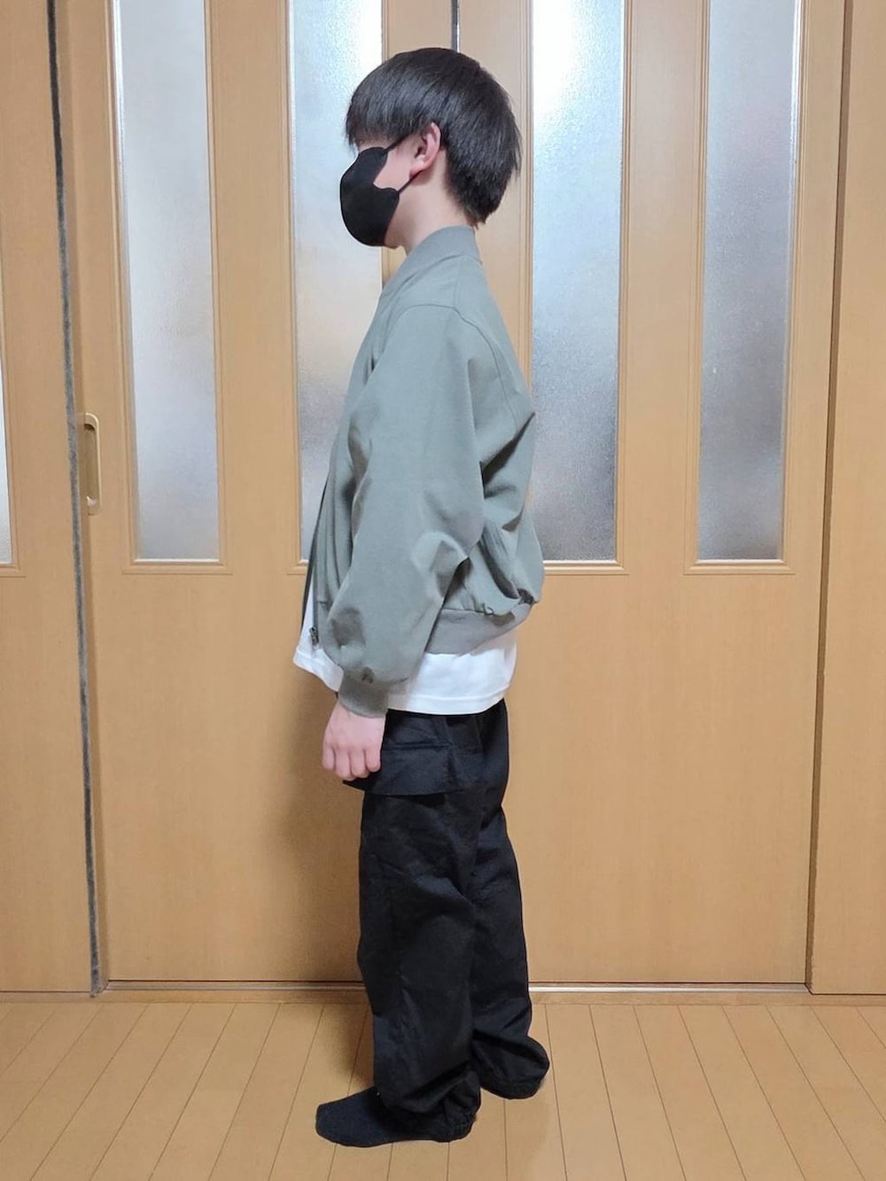 ブラック系のカーゴパンツ、グリーン系のMA-1、ホワイト系のTシャツ/カットソーを着用したキッズの春コーディネートの2枚目の写真