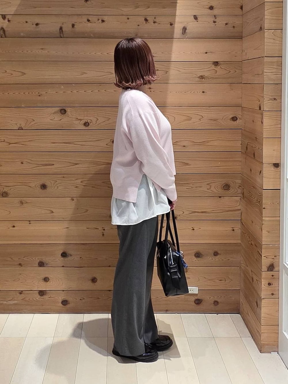 ブラック系のローファー、ブラック系のボストンバッグ、グレー系のスラックスを着用したレディースの春コーディネートの2枚目の写真