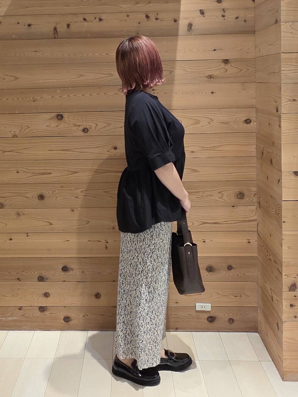 ブラック系のローファー、ブラウン系のショルダーバッグ、グレー系のスカートを着用したレディースの秋コーディネートの2枚目の写真