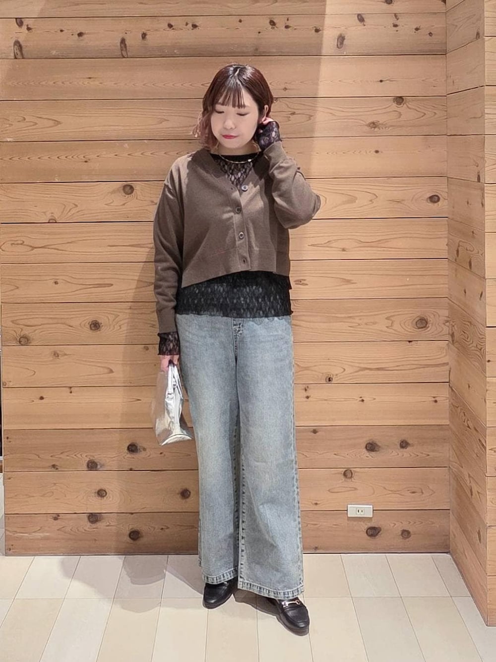 ブラック系のローファー、シルバー系のショルダーバッグ、ブルー系のデニムパンツを着用したレディースの春コーディネートの4枚目の写真