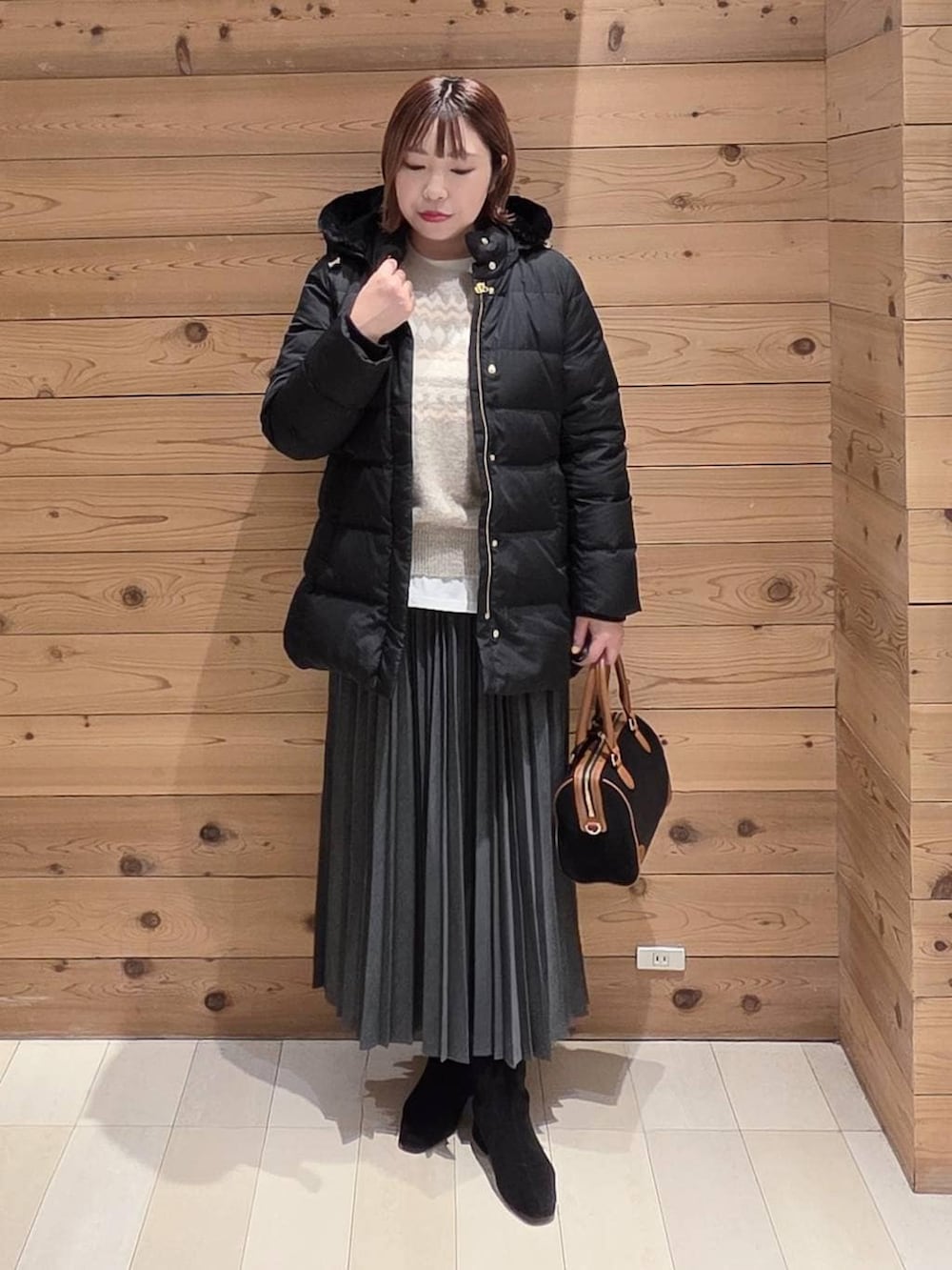 ブラック系のダウンジャケット/コート、グレー系のその他パンツ、ホワイト系のTシャツ/カットソーを着用したレディースの冬コーディネートの4枚目の写真