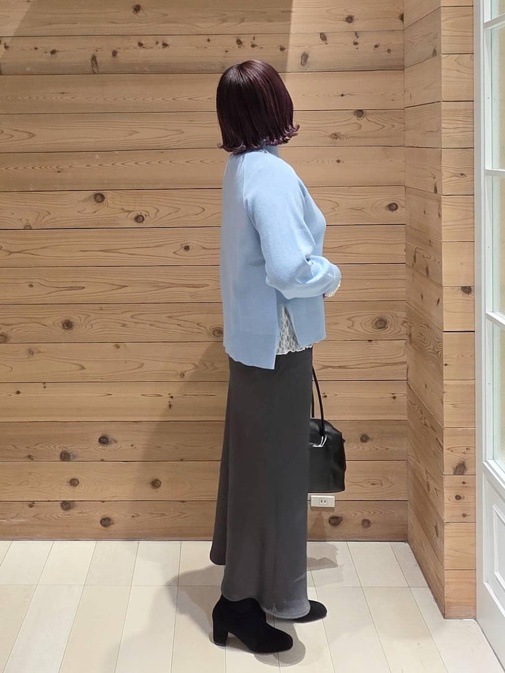 ブラック系のボストンバッグ、グレー系のチェスターコート、ホワイト系のTシャツ/カットソーを着用したレディースの冬コーディネートの2枚目の写真