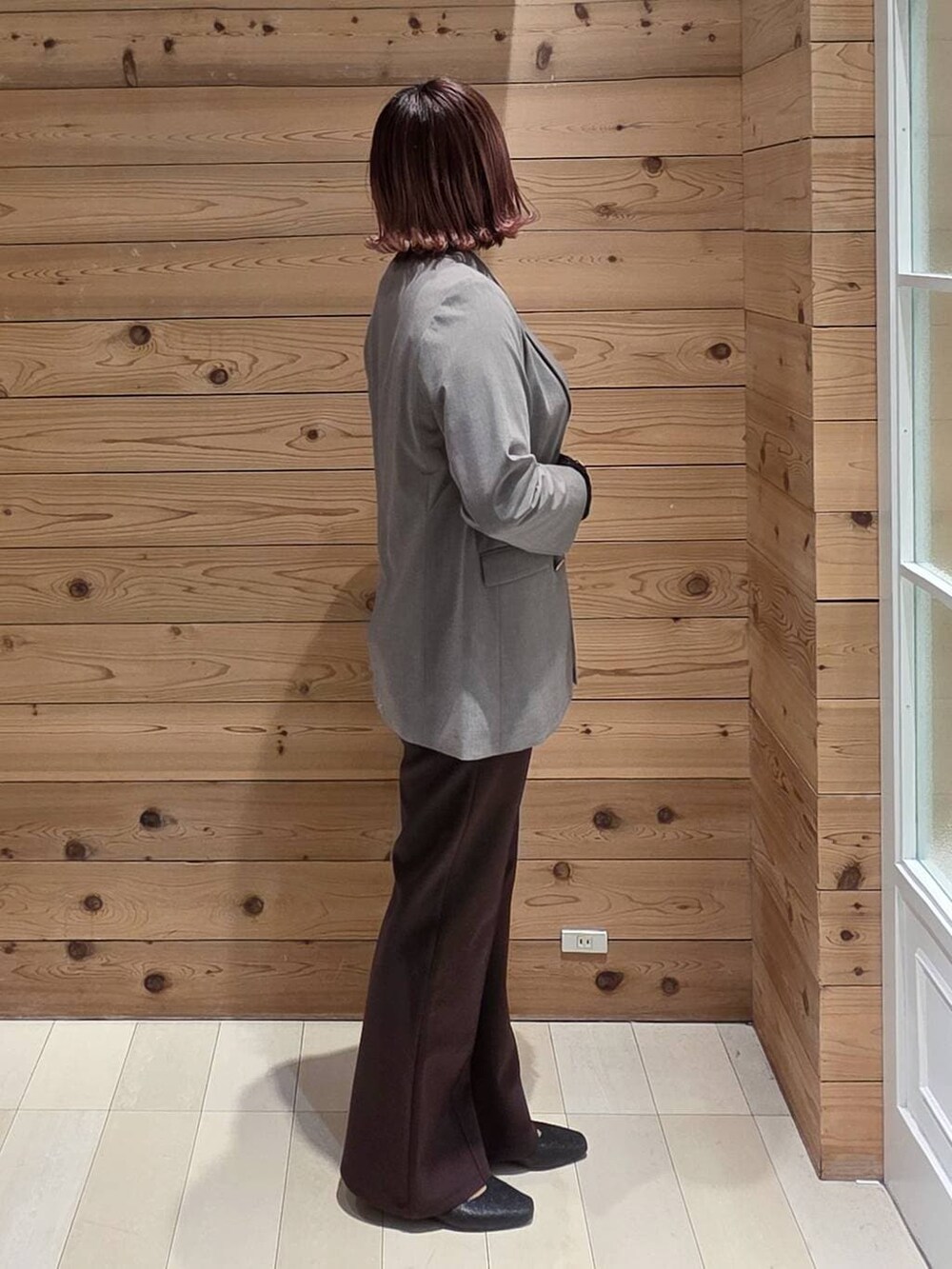 ブラック系のパンプス、ホワイト系のショルダーバッグ、ブラック系のTシャツ/カットソーを着用したレディースの冬コーディネートの2枚目の写真