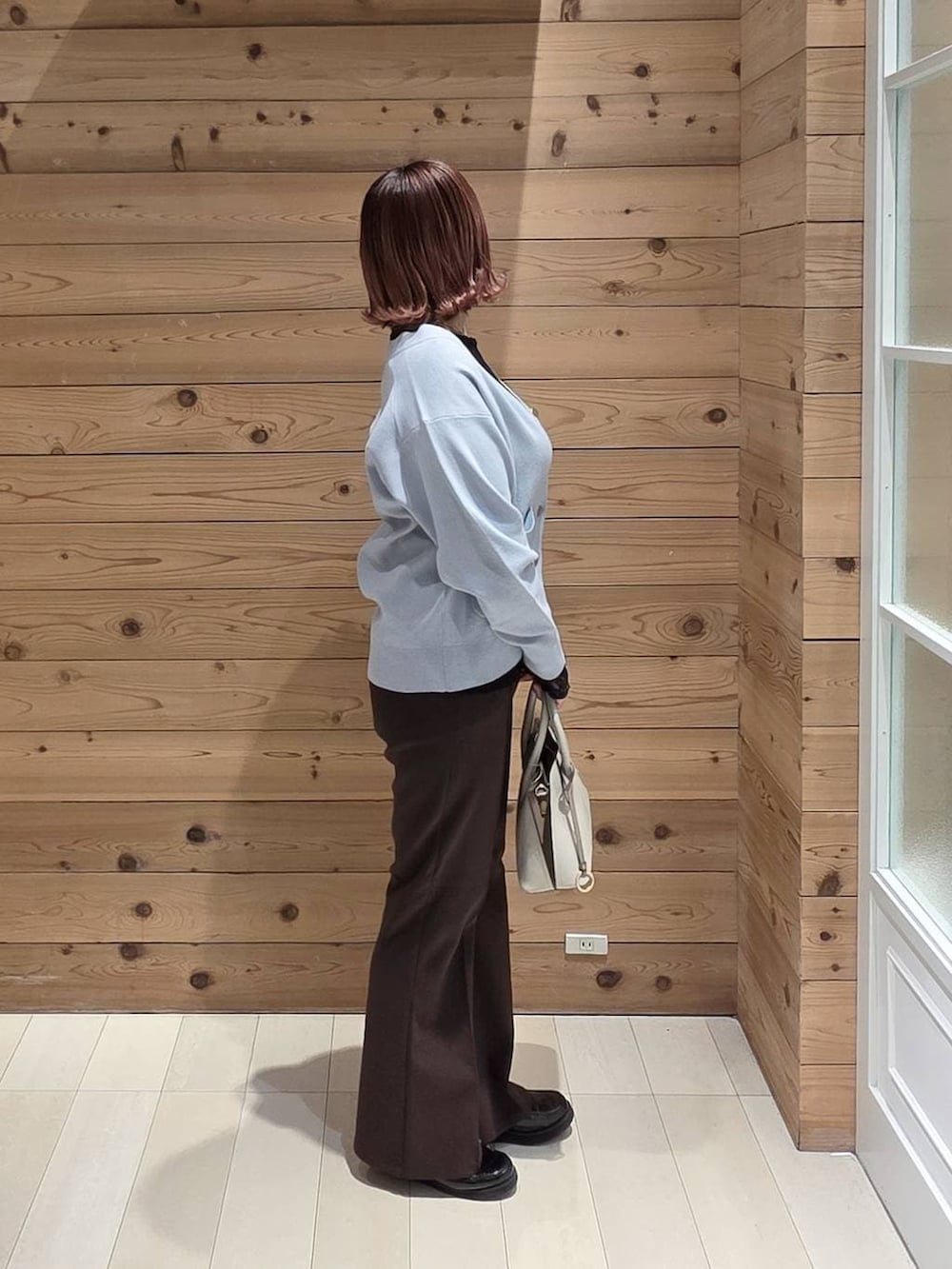 ブラック系のローファー、ホワイト系のショルダーバッグ、ブラック系のTシャツ/カットソーを着用したレディースの冬コーディネートの2枚目の写真