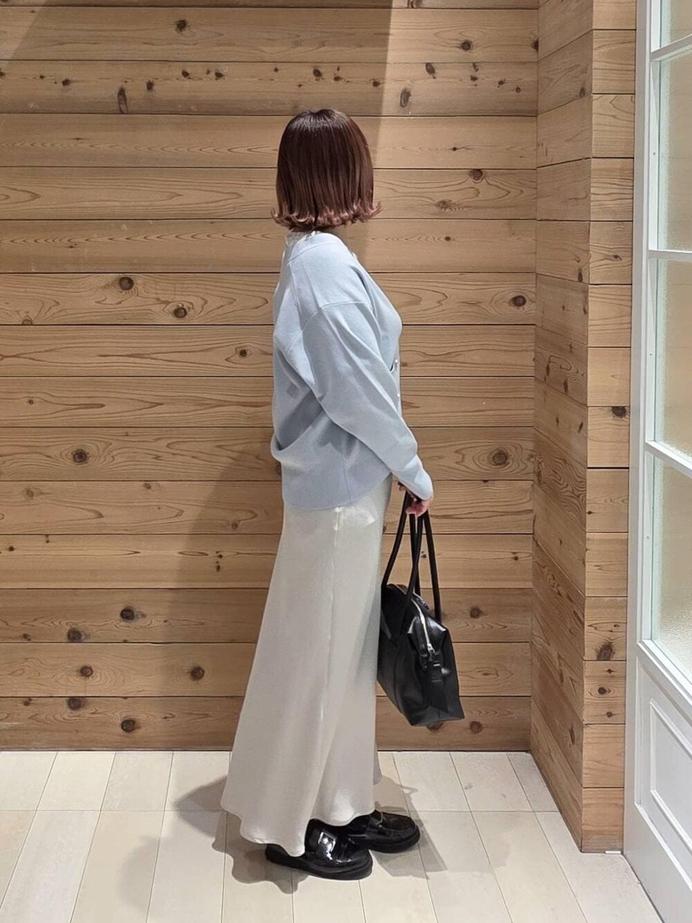 ブラック系のローファー、ブラック系のボストンバッグ、ブラック系のマウンテンパーカーを着用したレディースの春コーディネートの2枚目の写真